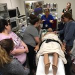 Pam deGravelles (center) gives nursing students an introduction to the operating room simulation suite and high-fidelity manikin.
