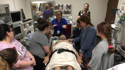 Pam deGravelles (center) gives nursing students an introduction to the operating room simulation suite and high-fidelity manikin.