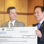 UAMS Chancellor Cam Patterson receives a donation supporting Regional Programs from Jung-Yul Choi, president of the Lions Club International Foundation.