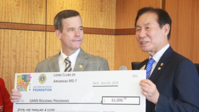 UAMS Chancellor Cam Patterson receives a donation supporting Regional Programs from Jung-Yul Choi, president of the Lions Club International Foundation.