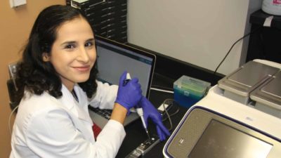 Alkam at lab bench with sequencer