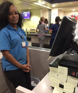Brittany Missouri, a cashier in the main UAMS cafeteria, works amid encouraging notes given to her during Kindness Week.