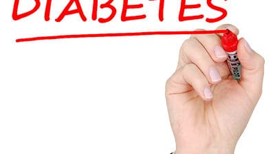 Someone writing the word Diabetes on a white board and underlining it