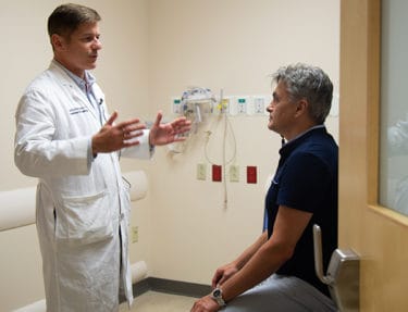 Martin Radvany, M.D., instructs Gamalie in some simple physical tests of his neurological health.