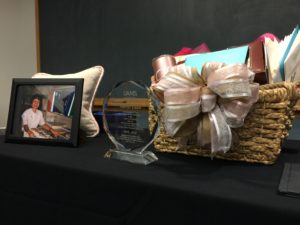 Coworkers presented Eisele with tokens of their thanks, including an award, gift basket, and book of pictures from her 20 years at JEI.
