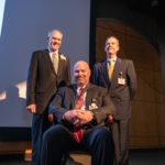 J.D. Day, M.D. (seated) wears his commemorative medallion from the investiture alongside UAMS College of Medicine Dean Christopher T. Westfall, M.D., FACS and UAMS Chancellor Cam Patterson, M.D., MBA.