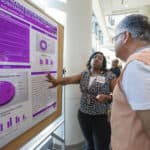 Kisa Vaughn, M.P.A., presents her poster to Reza Hakkak, Ph.D., on the Passion Project, which showed how additional health resources can improve health in African-American women with substance use disorder