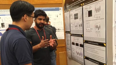 Maroof Zafar, center, discusses his research during a poster presentation at Cold Spring Harbor Laboratory.