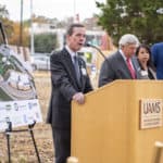 UAMS Chancellor Cam Patterson, left, speaks at the start of the groundbreaking ceremony for a $150 million energy project as UA Board of Trustees Chair John Goodson, Christina Clark, UAMS chief operating officer and Little Rock Mayor Frank Scott Jr. wait to address attendees.