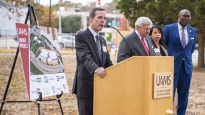 UAMS Chancellor Cam Patterson, left, speaks at the start of the groundbreaking ceremony for a $150 million energy project as UA Board of Trustees Chair John Goodson, Christina Clark, UAMS chief operating officer and Little Rock Mayor Frank Scott Jr. wait to address attendees.