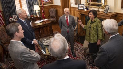 Teresita Bellido, UAMS' newest ARA Scholar, second from right, talks to UAMS Chancellor Cam Patterson, left and Gov. Asa Hutchinson, second from left and other dignitaries before the formal ceremony recognizing her as an ARA Scholar.