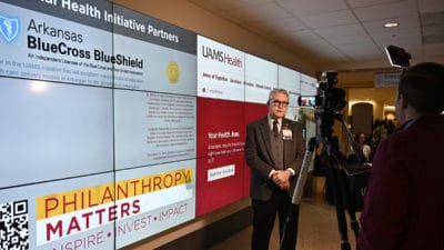 Curtis Lowery, M.D., left, answers questions during a television interview about the new UAMS HealthNow, 24-hour, online convenience health care service.
