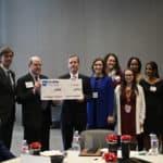 UAMS Chancellor Cam Patterson, M.D., MBA, receives the check from Patrick O'Sullivan, Blue & You Foundation executive director. Beau Blair Jr., UAMS Board of Advisors chair (at left) also accepted along with members of the AR-IMPACT team.