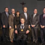 Scott Dickson, M.D. (seated) was invested Feb. 6 in the chair, which is awarded on a three-year, rotating basis.