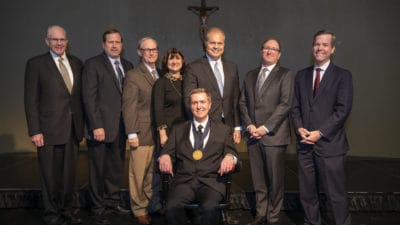 Scott Dickson, M.D. (seated) was invested Feb. 6 in the chair, which is awarded on a three-year, rotating basis.