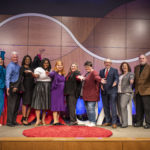 The 10 TEDxUAMS presenters and some of team that put on the event celebrate on stage at the end of the day.