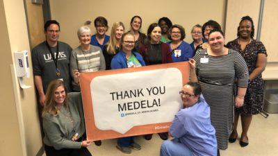 Group holding Medela sign