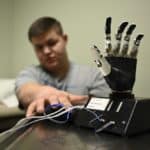 Bryce Cook reaches toward a therapy tool used to help patients learn to use muscle sensors to control a robotic prosthetic.