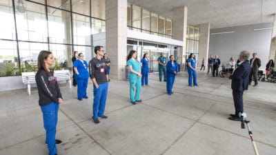 UAMS Medical Center CEO Steppe Mette, M.D., right, at the main entrance to the medical center speaks to the nurses and respiratory therapists volunteering to go to New York City to help care for COVID-19 patients.