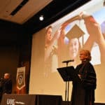 Melanie Reinhardt, Pharm.D., right, and Eddie Dunn, Pharm.D., left, read out the names of College of Pharmacy graduates as each is hooded on live video June 13 at the college's Honors Convocation.