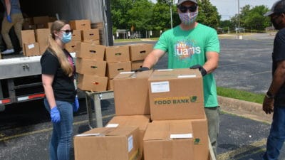Peter Cooper of UAMS Northwest unloads a truck of food relief boxes.