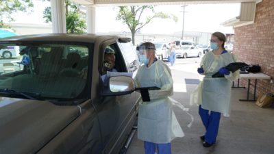 Robert Hopkins Jr., M.D., and Mary Caroline Kemp, RN, conduct a drive-thru screening for resident Ed Randall.