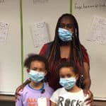 Natasha Gayden, a paraprofessional with the Little Rock School District who usually works with preschool children, cares for Brianna and Tenley Lewis and other students at the UAMS Day Camp at Pulaski Heights Elementary and Middle Schools while the childrens' parents work at UAMS.