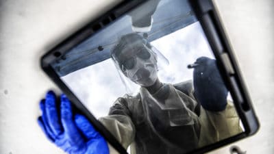 Working at the COVID-19 testing drive-thru at Shorter College in North Little Rock, a UAMS nurse takes a minute to enter some patient information into an iPad.