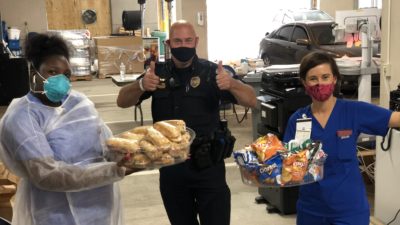 Deb Hutts, Sgt. Greg McKinney and Yukari Juniel offer thanks for lunches donated by members of the Arkansas Legislature to those working COVID-19 screening sites at UAMS.