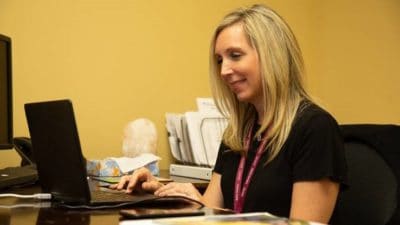 Christie Kelly, a licensed clinical social worker and clinic supervisor for AR-Connect, is shown talking to a client via live video.