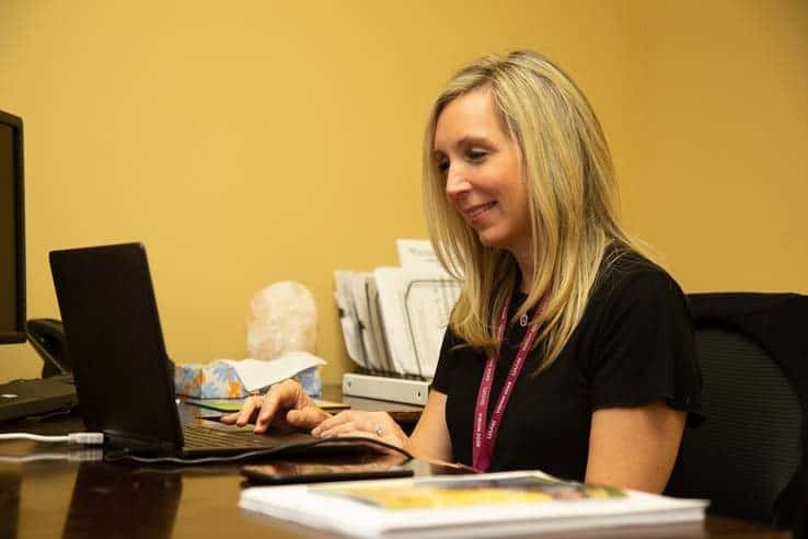 Christie Kelly, a licensed clinical social worker and clinic supervisor for AR-Connect, is shown talking to a client via live video.