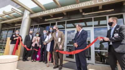 Dr. Patterson cutting clinic ribbon
