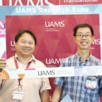 Yuet-Kin “Ricky” Leung, Ph.D. (left), won the 2020 Research Expo's Grand Door Prize, a manuscript submission fee to be paid by TRI. Leung also enjoyed the 2019 Expo, above with Nagai C. "Neville" Tam, Ph.D. (File Photo)