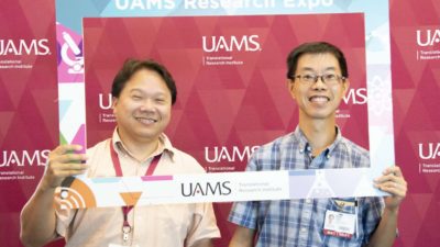 Yuet-Kin “Ricky” Leung, Ph.D. (left), won the 2020 Research Expo's Grand Door Prize, a manuscript submission fee to be paid by TRI. Leung also enjoyed the 2019 Expo, above with Nagai C. "Neville" Tam, Ph.D. (File Photo)
