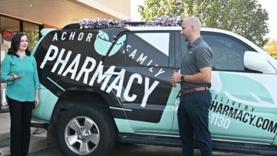 Megan Smith, left, talks to Brandon Achor on Oct. 1 outside Achor Family Pharmacy in Maumelle. Oct. 1 was the official launch date for the Flip the Pharmacy program in Arkansas.