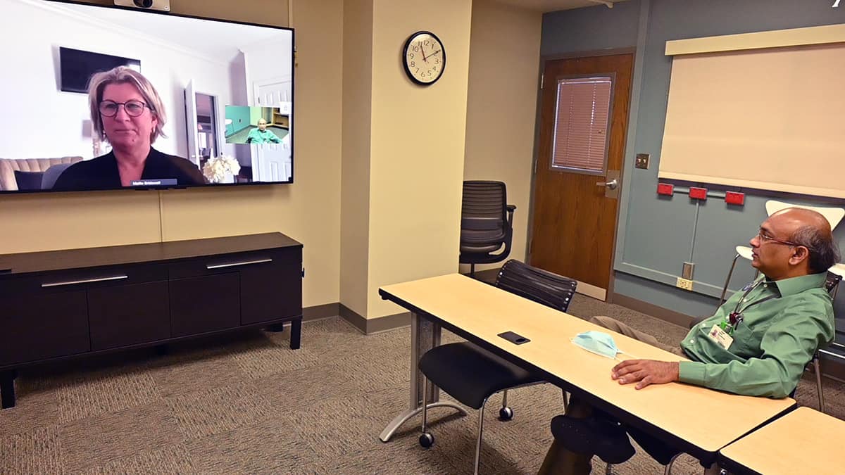 Hari Eswaran, right, uses a live video connection at the UAMS Institute for Digital Health & Innovation to talk with Mellie Bridewell, executive director of the Arkansas Rural Health Partnership.