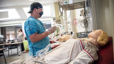 Respiratory Care student John Smith practices setting up an air entrainment mask.