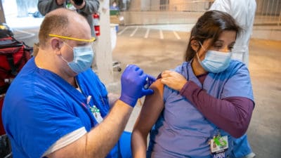 Barb McDonald, APRN, receives the COVID-19 vaccine on Tuesday, Dec. 15. UAMS received its first allocation of 2,000 doses to vaccinate critical health care employees.
