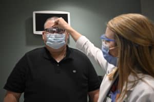 Price demonstrates a hands-free magnifying device that clips onto a pair of glasses. 