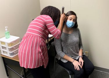 Students in the new Speech and Hearing Clinic location practice conducting ear examinations.