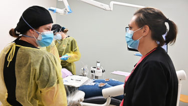 Claire Tucker, right, talks to a dental hygiene student at the sealant clinic.