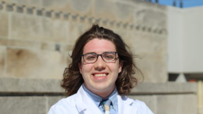 Mason Belue standing outside in white coat