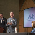 UAMS Chancellor Cam Patteson, center, answers a question in writing from a member of the Town Hall audience that was read out loud by Michael Manley, left, as Provost Stephanie Gardner listens.
