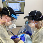 Two dental hygiene students help a patient in a operatory in the new UAMS Dental Hygiene Clinic. All students are supervised by faculty and instructors in the clinic.