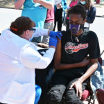 A UAMS nurse injects Cameron Henry with a COVID-19 vaccine.