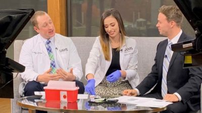 Christopher Johnson, Pharm.D., and then-P3 student Kathryn Barfield demonstrate blood glucose testing with KATV on behalf of APhA Operation Diabetes on November 14, 2019.