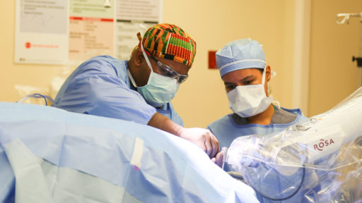 Analiz Rodriguez, M.D., Ph.D., and neurosurgical resident Marcus Stephens, M.D. perform surgery.