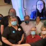 Veronica Ussery (on screen) is joined with (front right) Karen J. Dickinson, M.D.; (second row, left to right) Patti Griffey, a simulated patient, and Sherry Johnson; and (third row, left to right) Jerry Halpain, Andrew Warr, simulated patient, Margaret Glasgow, Matthew Spond, M.D., and another simulated patient.