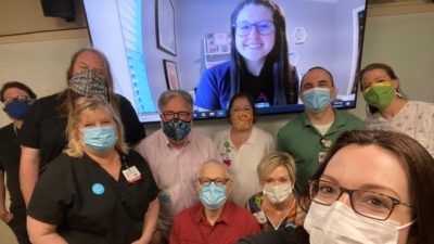 Veronica Ussery (on screen) is joined with (front right) Karen J. Dickinson, M.D.; (second row, left to right) Patti Griffey, a simulated patient, and Sherry Johnson; and (third row, left to right) Jerry Halpain, Andrew Warr, simulated patient, Margaret Glasgow, Matthew Spond, M.D., and another simulated patient.