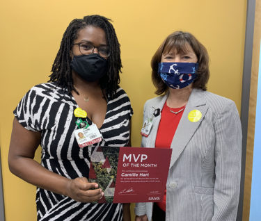 Camille Hart, left, and UAMS Provost Stephanie Gardner, Pharm.D., Ed.D., stop for a photo just after Gardner presented her with the MVP award.